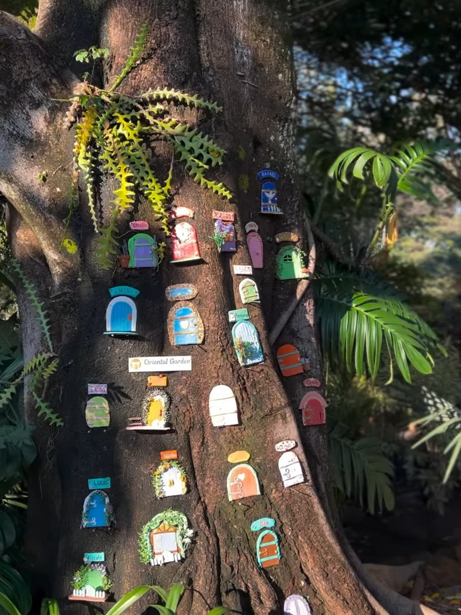 Tronco de árvore decorado com portinhas coloridas pintadas à mão