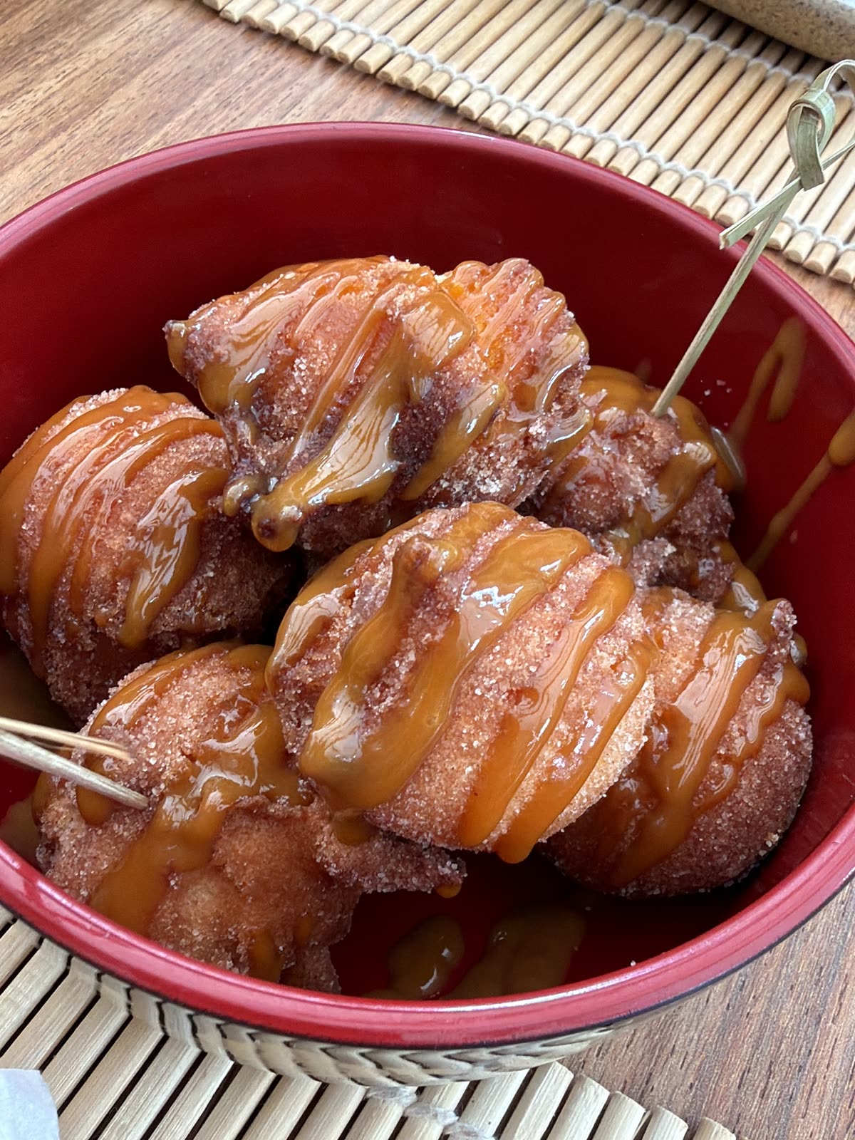 Bolinhos-de-chuva com calda numa tigela vermelha